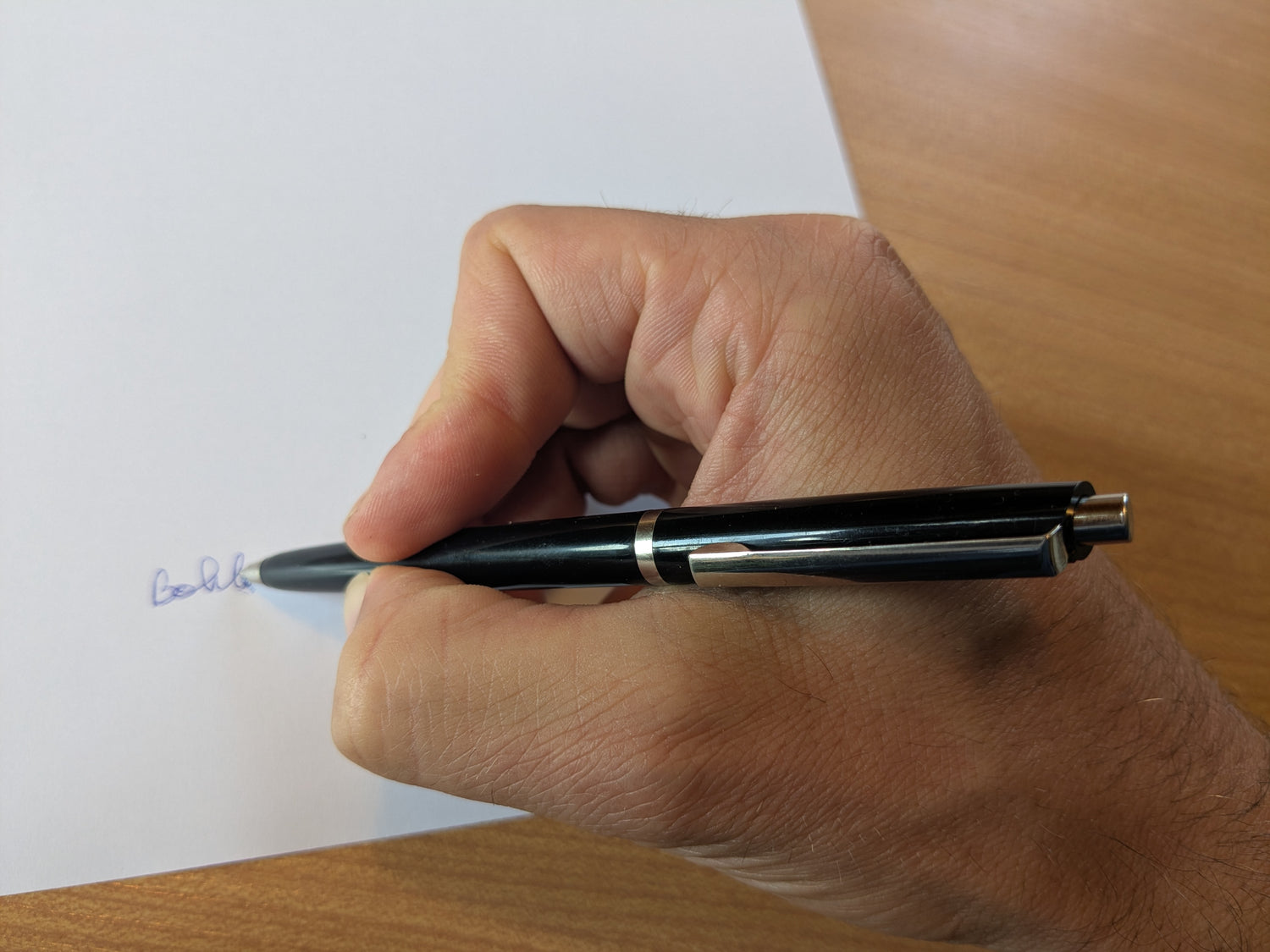 Hand schreibt mit Kugelschreiber auf Papier als Teil eines kreativen Prozesses