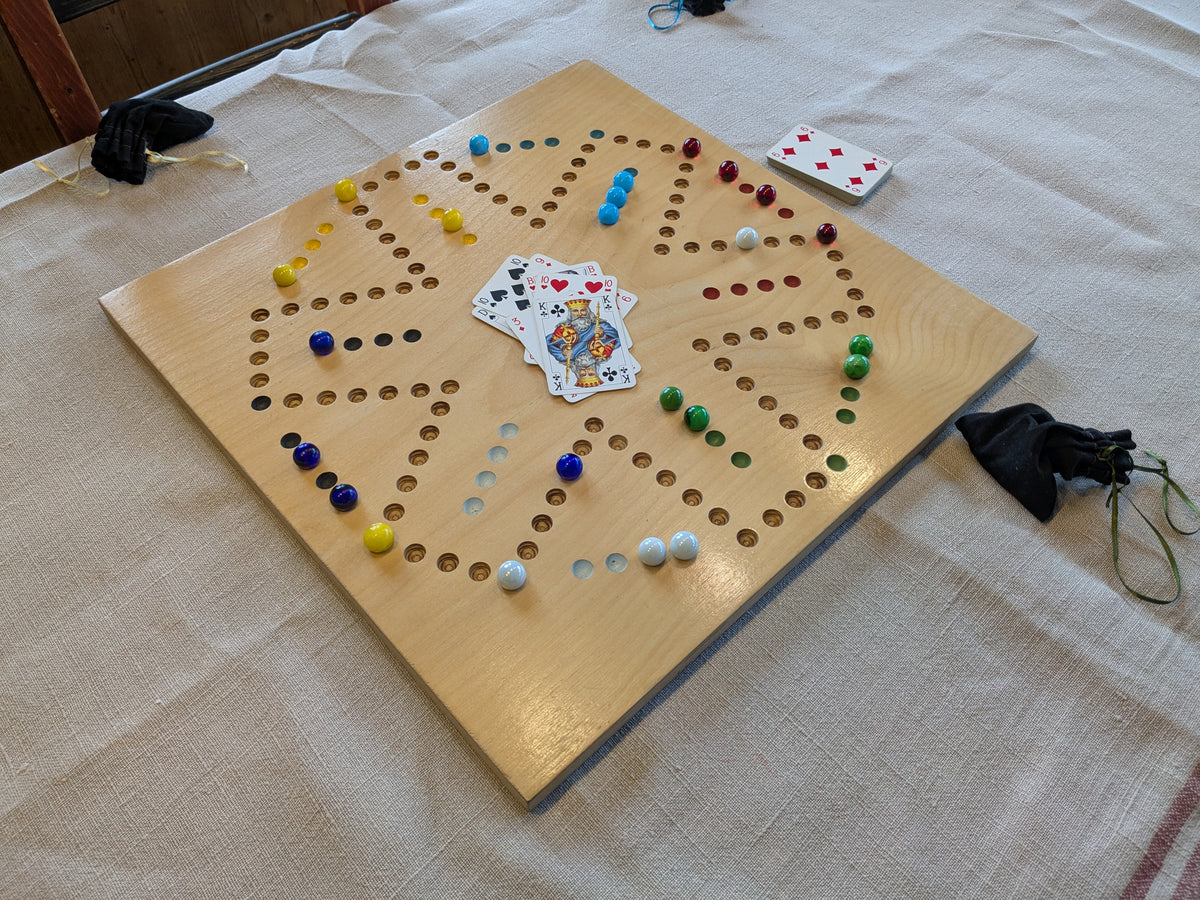 Dog Brettspiel aus Holz mit farbigen Kugeln und Karten auf einer Stoffunterlage