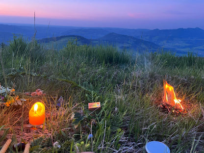 Räuchermischung Sommersonnenwende für Rituale mit Feuer und Kerze in den Bergen kurz nach Sonnenuntergang.