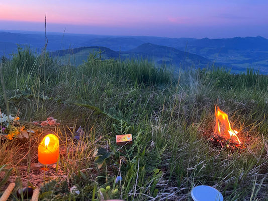 Räuchermischung Sommersonnenwende für Rituale mit Feuer und Kerze in den Bergen kurz nach Sonnenuntergang.