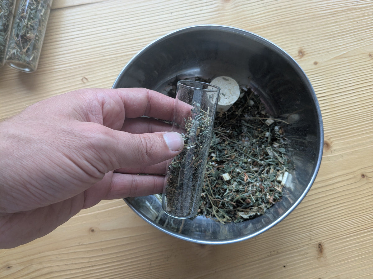 Sommersonnenwende Räuchermischung in reagenzglas mit Beifuß, Johanniskraut, Mädesüß, Föhre, Copal & Thymian wird von hand abgefüllt.